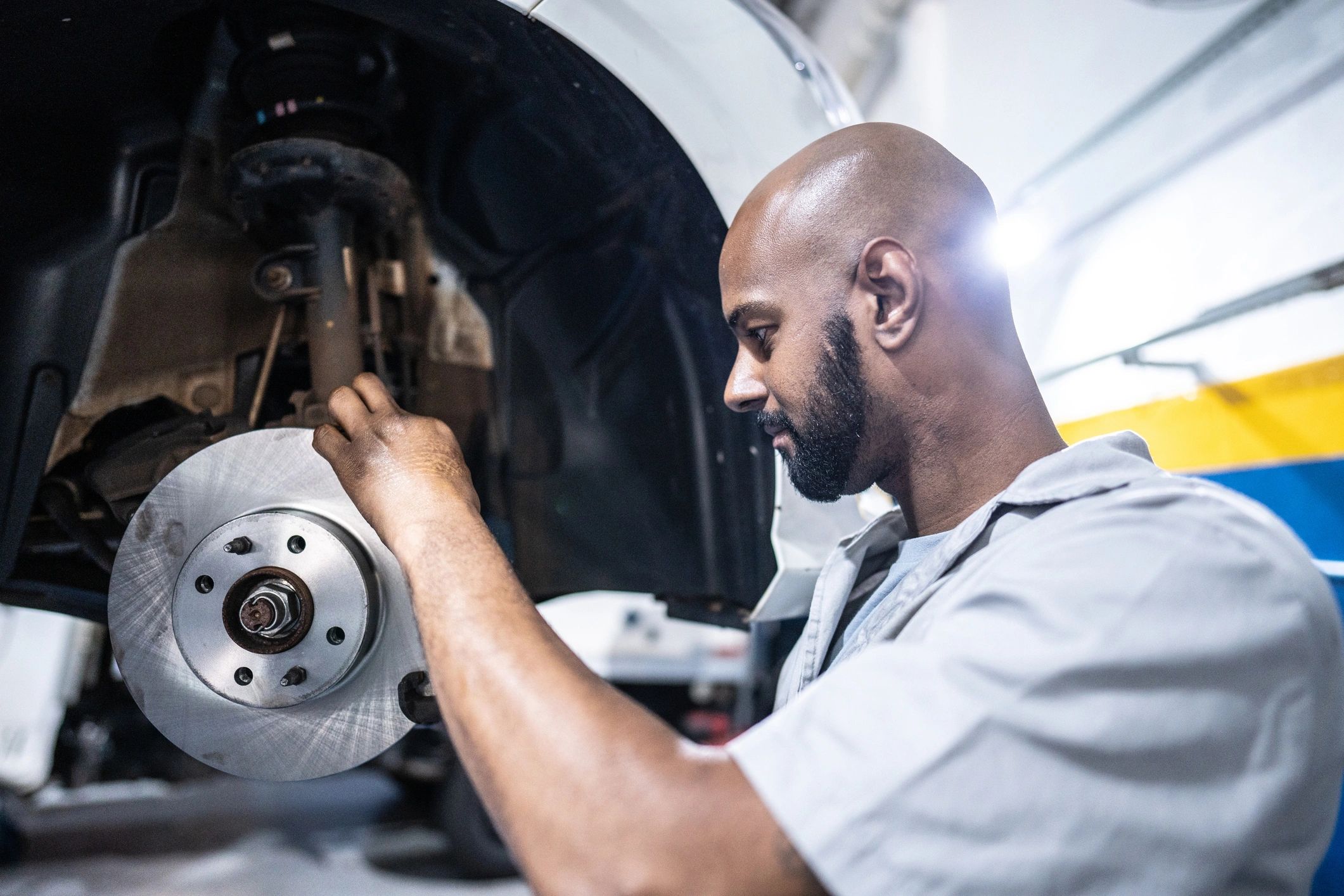 Mechanic servicing a vehicle in an auto repair shop