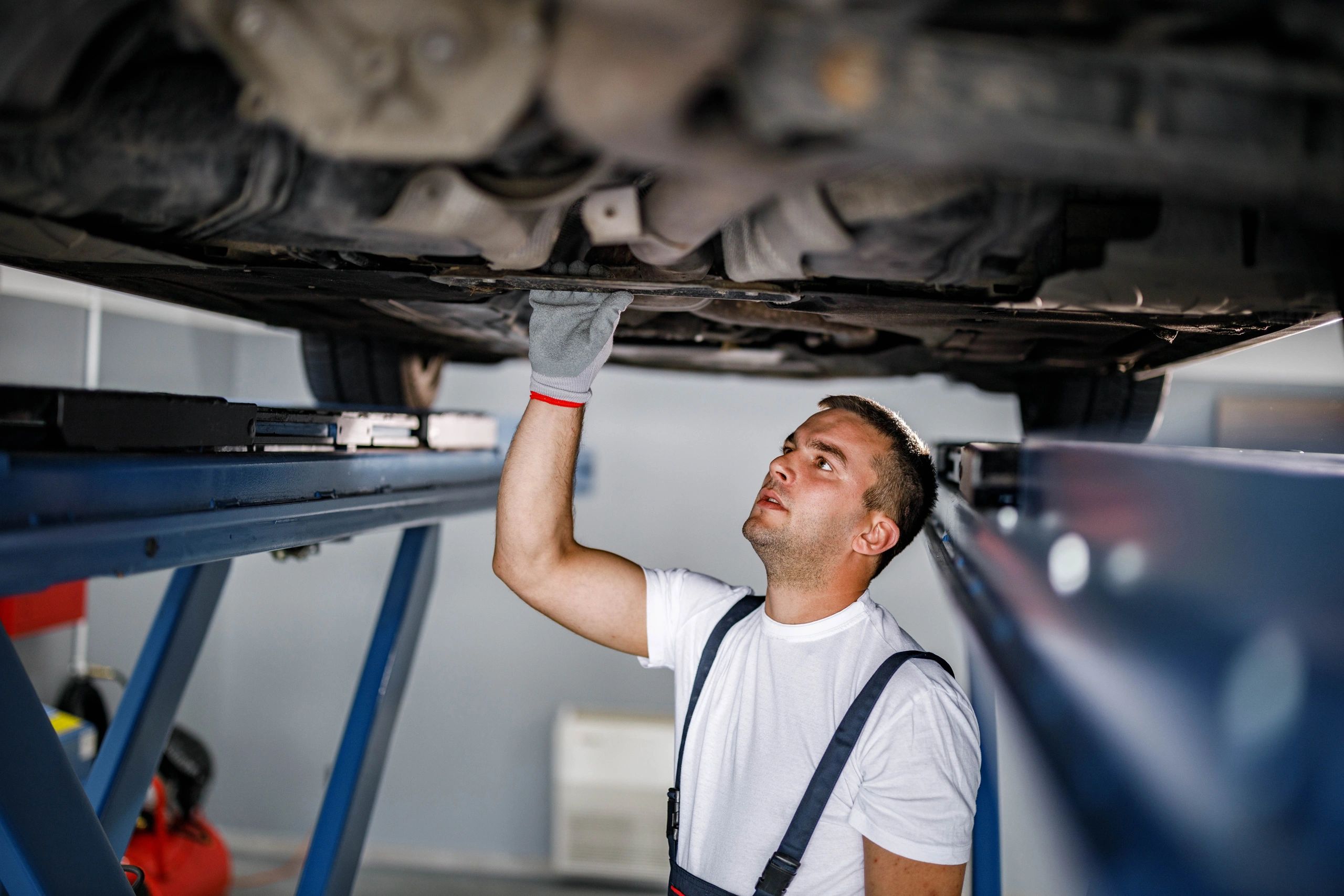 Mechanic inspecting the underside of a car during service