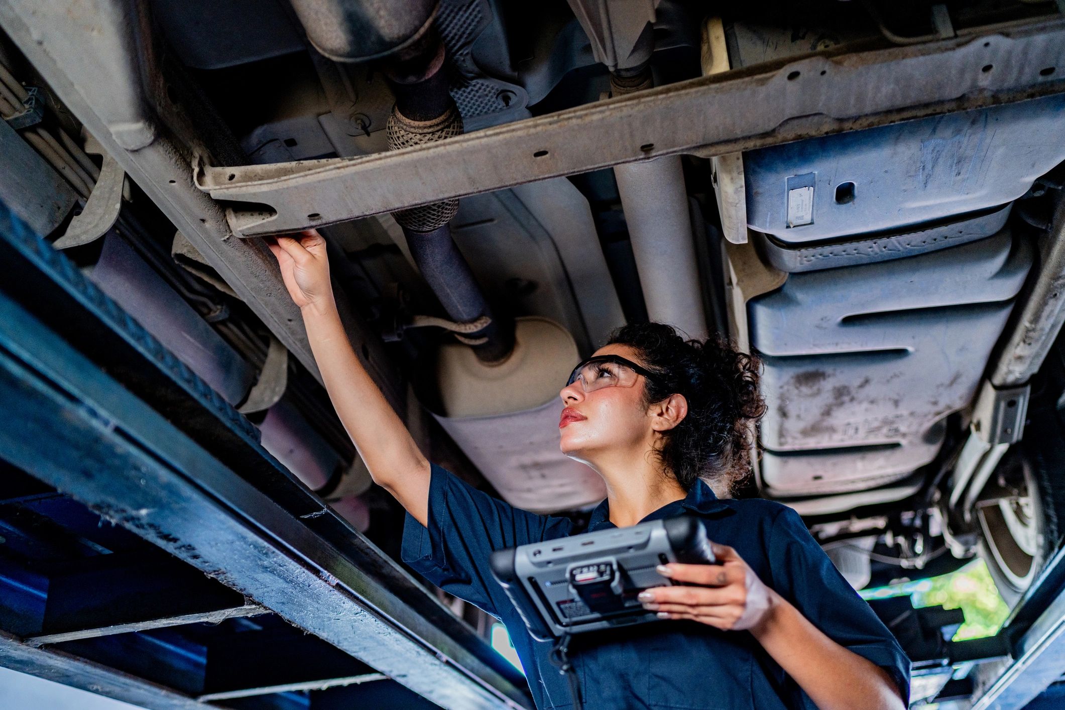Technician inspecting a vehicle at an auto repair shop