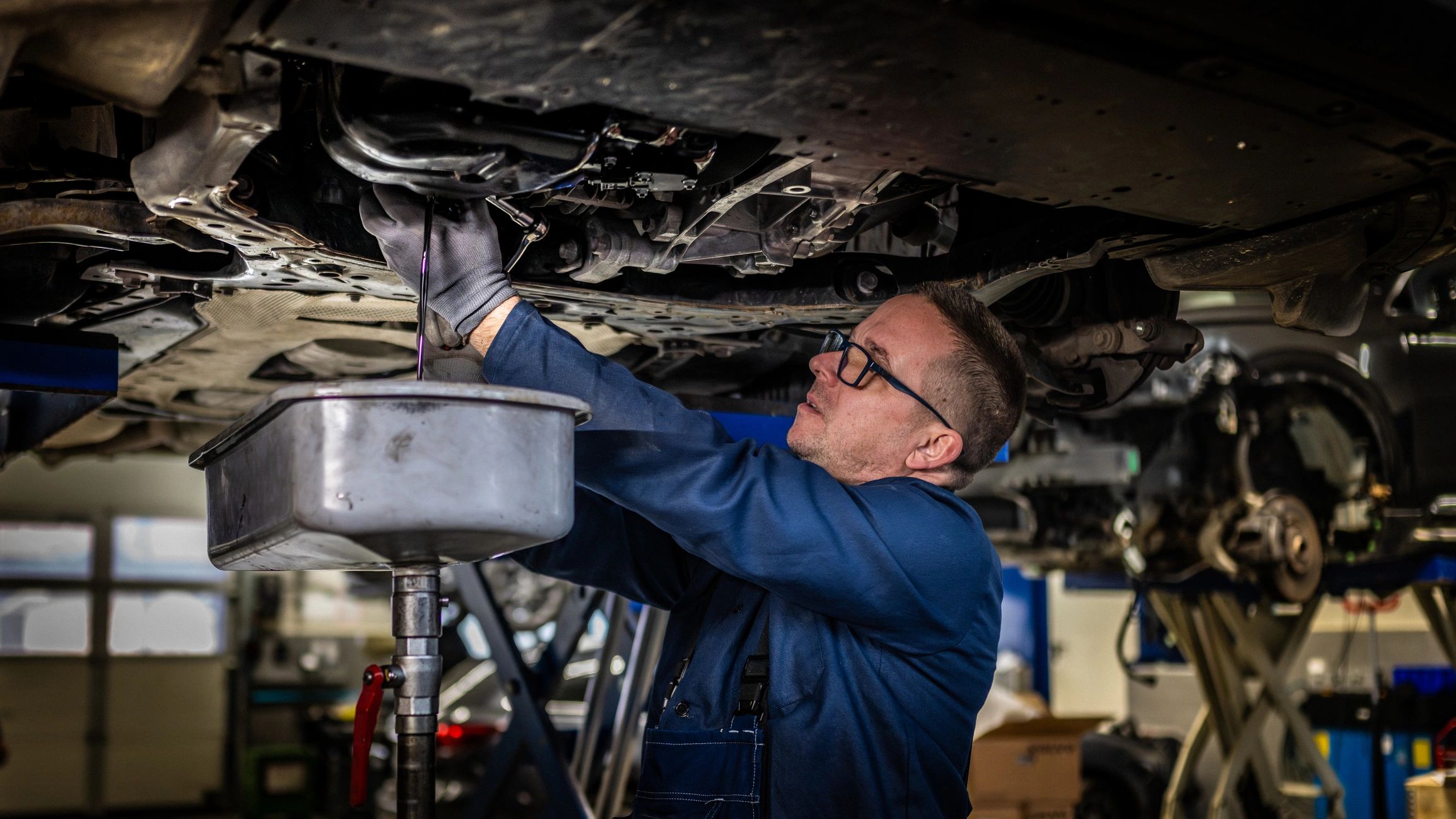 Technician changing engine oil in a service bay