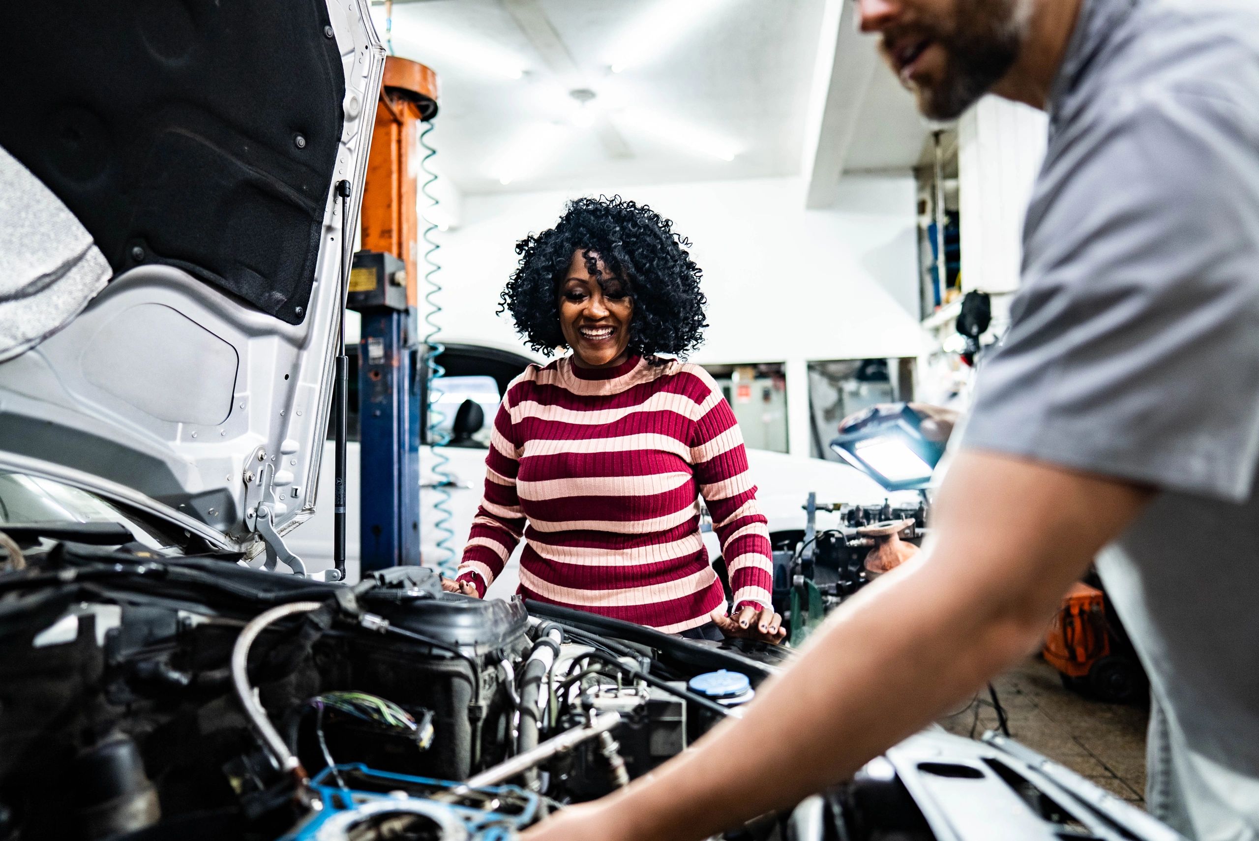 Customer speaking with a mechanic at an auto repair shop