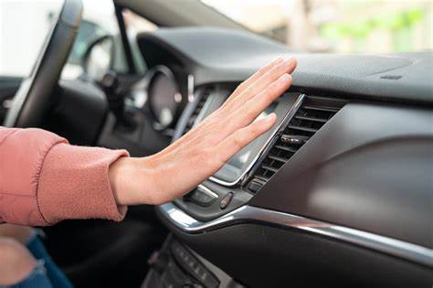 Person adjusting car dashboard controls with hand.